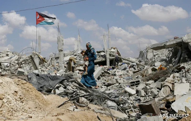 A Palestinian woman walks on the ruins of her house, which witnesses said was destroyed by an Israeli air strike during a seven-week offensive, in the east of Khan Younis in the southern Gaza Strip September 13, 2014. An...