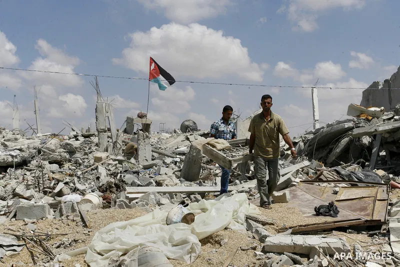 Palestinians walk on the ruins of houses, which witnesses said were destroyed by an Israeli air strike during a seven-week offensive, in the east of Khan Younis in the southern Gaza Strip September 13, 2014. An open-ende...