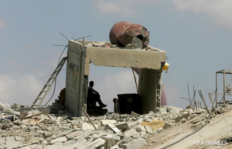 A Palestinian man sits atop the ruins of his house, which witnesses said was destroyed by an Israeli air strike during a seven-week offensive, in the east of Khan Younis in the southern Gaza Strip September 13, 2014. An...