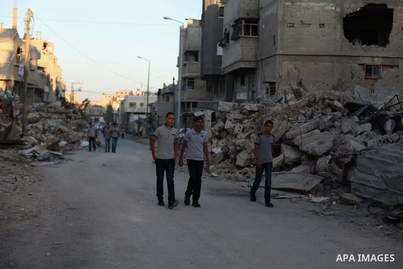 Palestinian students walk past houses that witnesses said were destroyed by the Israeli offensive, as they make their way to school on the first day of the new school year in the east of Gaza City September 14, 2014. An...