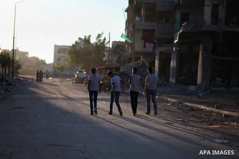 Palestinian students walk past houses that witnesses said were destroyed by the Israeli offensive, as they make their way to school on the first day of the new school year in the east of Gaza City September 14, 2014. An...