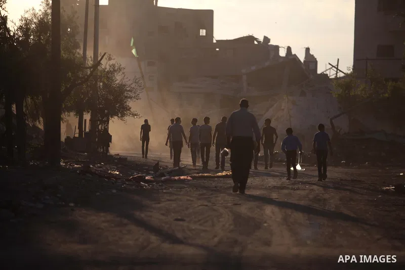 Palestinian students walk past houses that witnesses said were destroyed by the Israeli offensive, as they make their way to school on the first day of the new school year in the east of Gaza City September 14, 2014. An...
