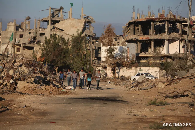 Palestinian students walk past houses that witnesses said were destroyed by the Israeli offensive, as they make their way to school on the first day of the new school year in the east of Gaza City September 14, 2014. An...