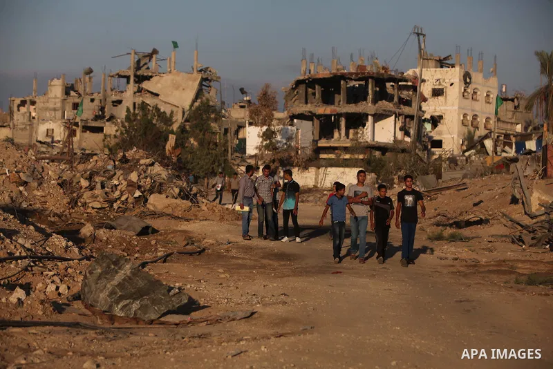 Palestinian students walk past houses that witnesses said were destroyed by the Israeli offensive, as they make their way to school on the first day of the new school year in the east of Gaza City September 14, 2014. An...