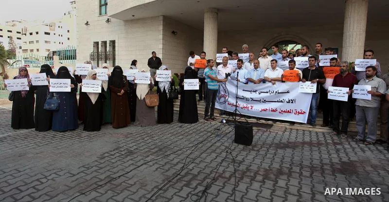 Palestinian Teachers union hold banners during a protest to demand their salaries, on the first day of the new school year in Gaza City September 14, 2014. An open-ended ceasefire between Israel and Hamas-led Gaza milita...