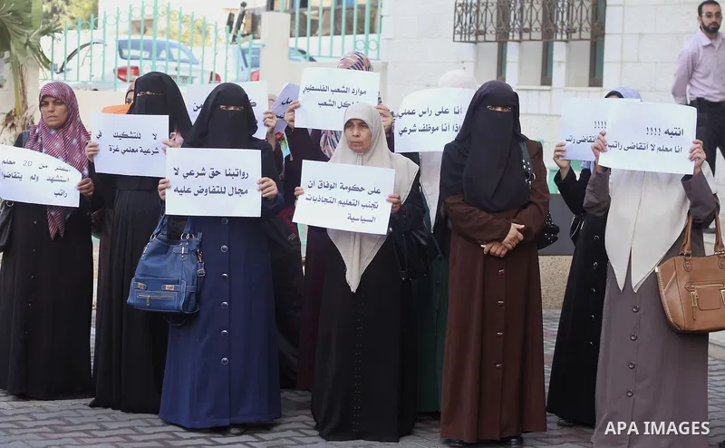 Palestinian Teachers union hold banners during a protest to demand their salaries, on the first day of the new school year in Gaza City September 14, 2014. An open-ended ceasefire between Israel and Hamas-led Gaza milita...