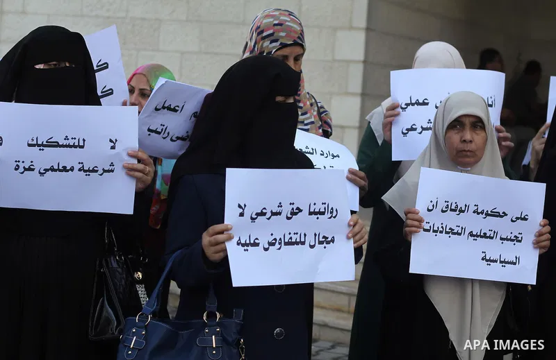 Palestinian Teachers union hold banners during a protest to demand their salaries, on the first day of the new school year in Gaza City September 14, 2014. An open-ended ceasefire between Israel and Hamas-led Gaza milita...