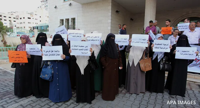 Palestinian Teachers union hold banners during a protest to demand their salaries, on the first day of the new school year in Gaza City September 14, 2014. An open-ended ceasefire between Israel and Hamas-led Gaza milita...