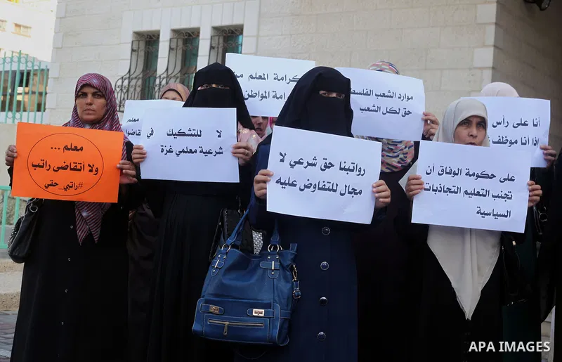 Palestinian Teachers union hold banners during a protest to demand their salaries, on the first day of the new school year in Gaza City September 14, 2014. An open-ended ceasefire between Israel and Hamas-led Gaza milita...