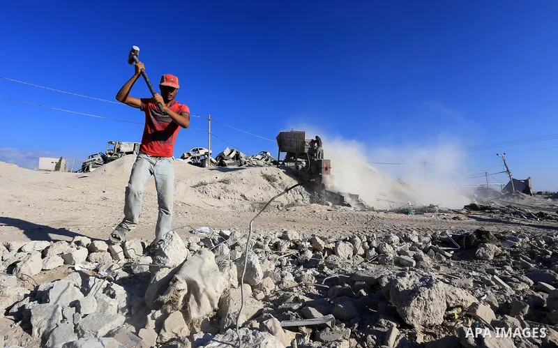Palestinian workers smash large stones into small gravels to be used for building houses that witnesses said were destroyed by Israel during its offensive, in Gaza City September 14, 2014. An open-ended ceasefire between...