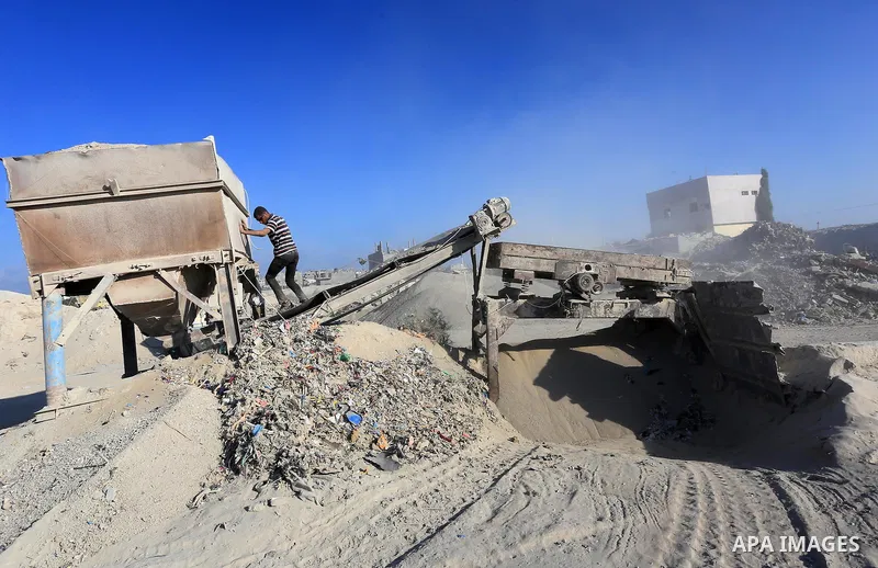 Palestinian workers smash large stones into small gravels to be used for building houses that witnesses said were destroyed by Israel during its offensive, in Gaza City September 14, 2014. An open-ended ceasefire between...