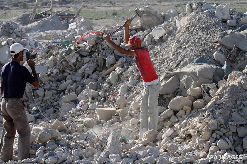Palestinian workers smash large stones into small gravels to be used for building houses that witnesses said were destroyed by Israel during its offensive, in Gaza City September 14, 2014. An open-ended ceasefire between...