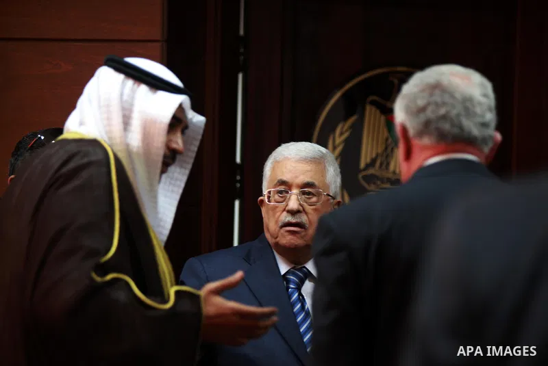 Palestinian President Mahmoud Abbas speaks with Kuwait's Minister of Foreign Affairs Sheikh Sabah al Khalid al Sabah and his Palestinian counterpart Riyad al-Maliki during a signing ceremony in the West Bank city of Rama...