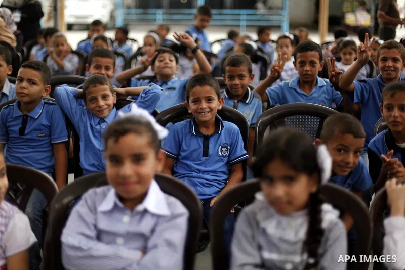 Palestinian students pose for a photograph during the visit of Pierre Krahenbuhl, United Nations Relief and Works Agency (UNRWA) Commissioner-Genera at a United Nations-run school on the first day of a new school year in...