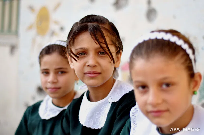 Palestinian students sit inside their school that witnesses said was shelled by Israel during its offensive, on the second day of the new school year in the east of Gaza City September 15, 2014. School year started in th...
