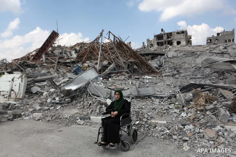 A Palestinian Injured woman sits near the rubbles of El-Wafa hospital, which witnesses said was destroyed during a seven-week Israeli offensive, in the east of Gaza City September 15, 2014. An open-ended ceasefire betwee...