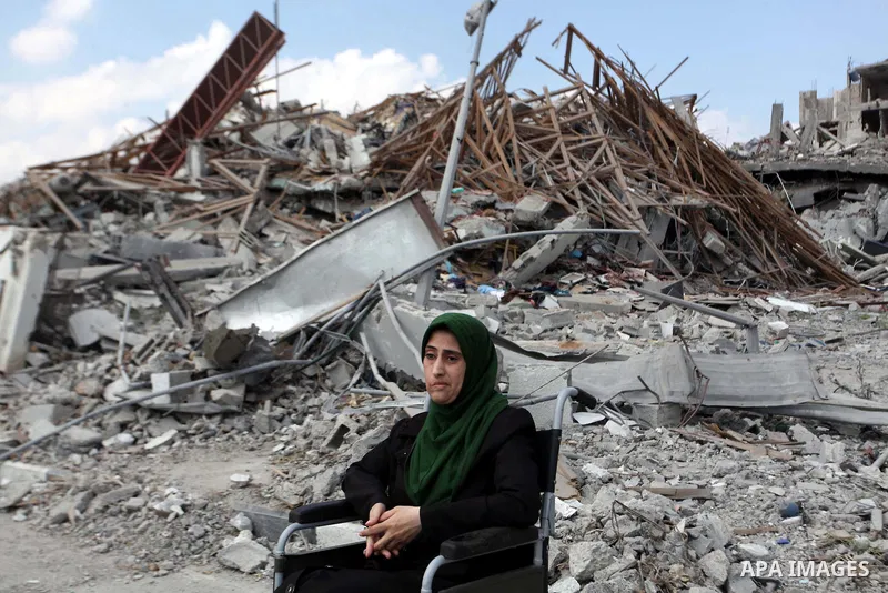 A Palestinian Injured woman sits near the rubbles of El-Wafa hospital, which witnesses said was destroyed during a seven-week Israeli offensive, in the east of Gaza City September 15, 2014. An open-ended ceasefire betwee...