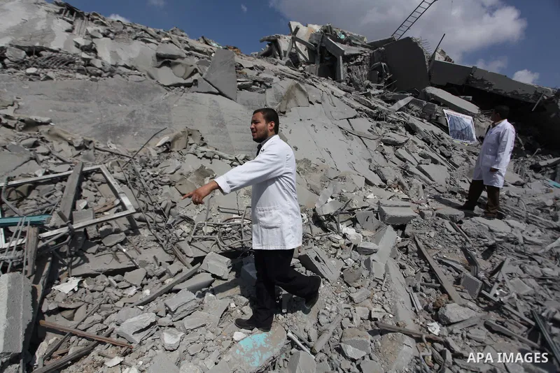 Palestinian doctors stand on the rubbles of El-Wafa hospital, which witnesses said was destroyed during a seven-week Israeli offensive, in the east of Gaza City September 15, 2014. An open-ended ceasefire between Israel...
