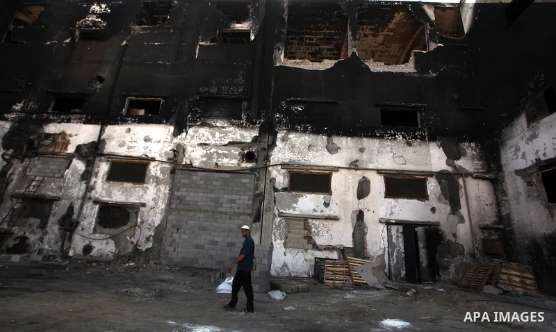 A Palestinian man inspects El-Awda factory that witnesses said was shelled by Israel during its offensive, in Gaza City September 16, 2014. An open-ended ceasefire between Israel and Hamas-led Gaza militants, mediated by...