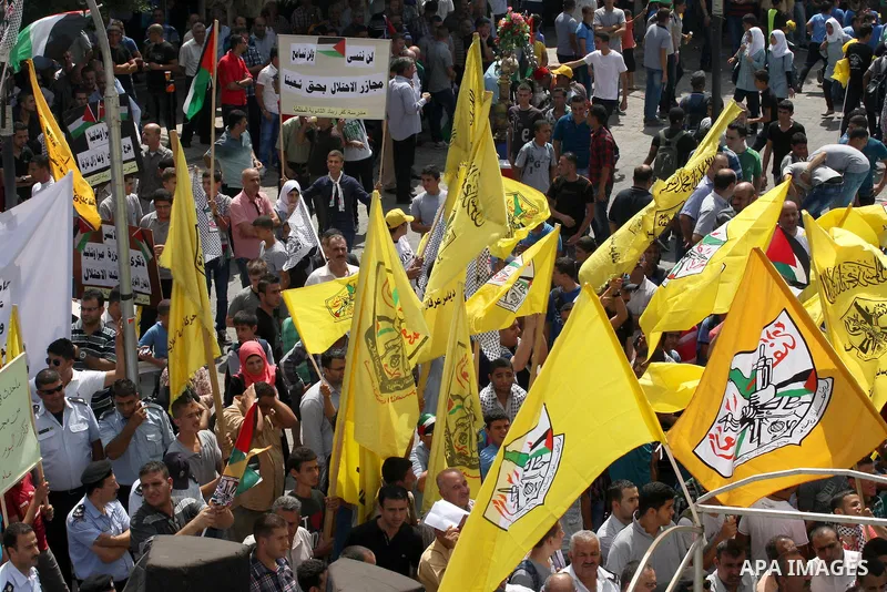Palestinian supporters of Fatah movement hold the movement's flags during a protest marking the 48th anniversary of the Sabra and Shatila massacre in 1982, in the West Bank city of Nablus, September 16, 2014. The Sabra a...