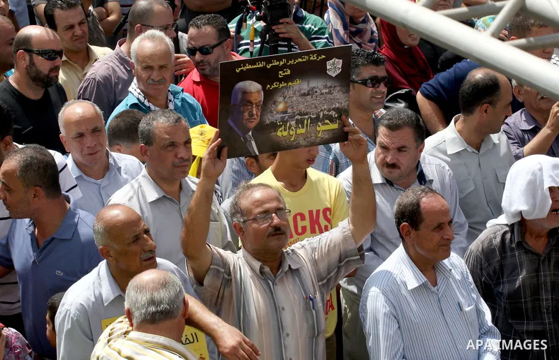A Palestinian Fatah supporter holds a picture of Palestinian President Mahmoud Abbas during a protest marking the 48th anniversary of the Sabra and Shatila massacre in 1982, in the West Bank city of Nablus, September 16,...
