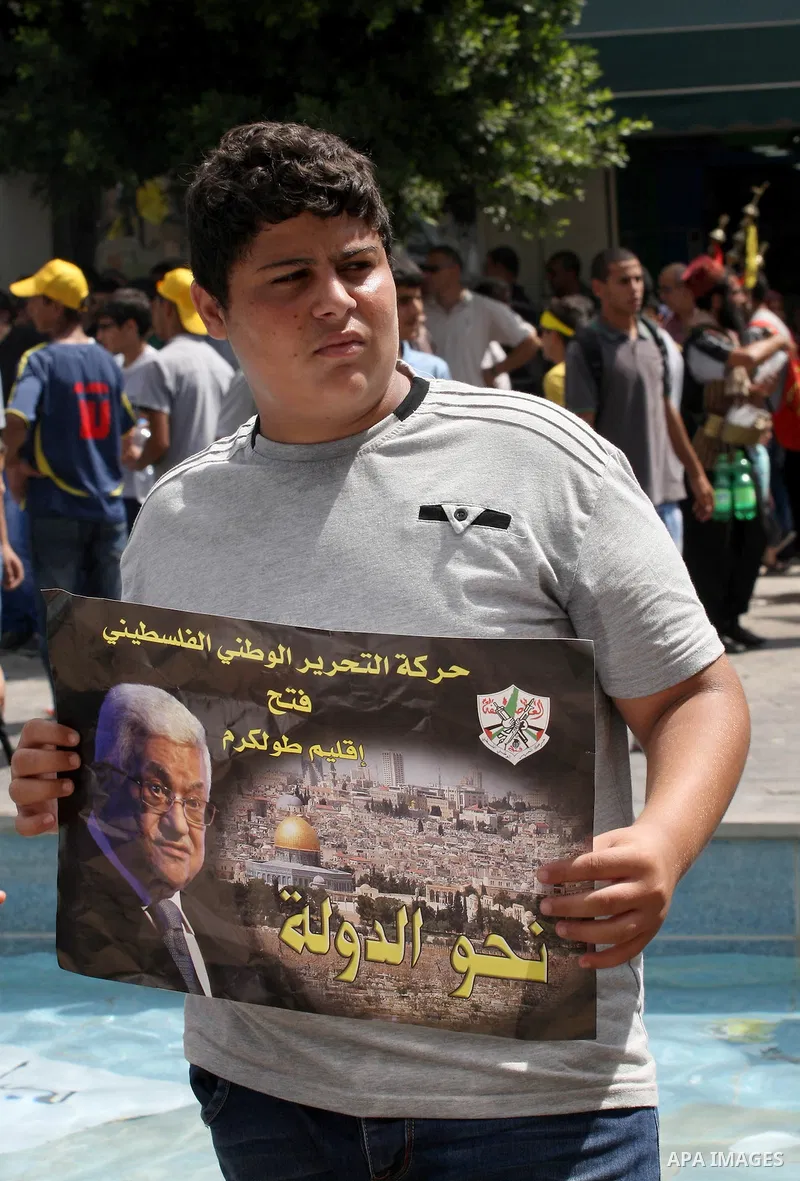 A Palestinian Fatah supporter holds a picture of Palestinian President Mahmoud Abbas during a protest marking the 48th anniversary of the Sabra and Shatila massacre in 1982, in the West Bank city of Nablus, September 16,...