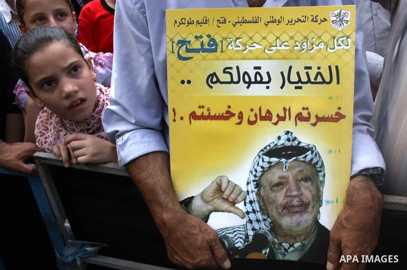 A Palestinian Fatah supporter holds a picture of former Palestinian leader Yasser Arafat during a protest marking the 48th anniversary of the Sabra and Shatila massacre in 1982, in the West Bank city of Nablus, September...
