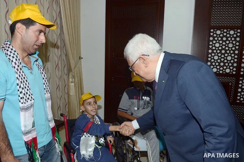 Palestinian President Mahmoud Abbas meets with citizens who were injured during the Israeli offensive on Gaza Strip, in the Abbas's headquarter in the West Bank city of Ramallah, September 16, 2014. Photo by Thaer Ganaim