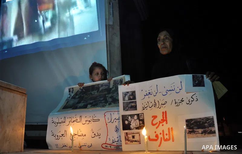 A Palestinian woman and her duaghter hold placards in a protest marking the 48th anniversary of the Sabra and Shatila massacre in 1982, in Gaza City September 16, 2014. The Sabra and Shatila massacre was the slaughter of...