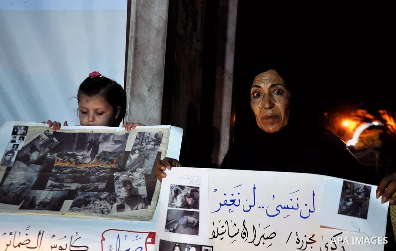 A Palestinian woman and her duaghter hold placards in a protest marking the 48th anniversary of the Sabra and Shatila massacre in 1982, in Gaza City September 16, 2014. The Sabra and Shatila massacre was the slaughter of...