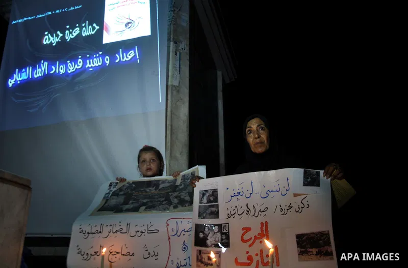 A Palestinian woman and her duaghter hold placards in a protest marking the 48th anniversary of the Sabra and Shatila massacre in 1982, in Gaza City September 16, 2014. The Sabra and Shatila massacre was the slaughter of...