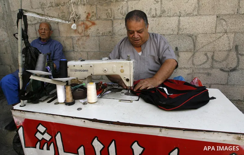 A Palestinian tailor works at a street market in Rafah in the southern Gaza Strip on Sept. 17, 2014. An open-ended ceasefire between Israel and Hamas-led Gaza militants, mediated by Egypt, took effect on August 26 after...