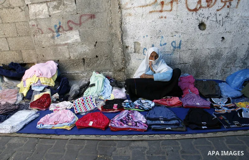 A Palestinian woman sells clothes at a street market in Rafah in the southern Gaza Strip on Sept. 17, 2014. An open-ended ceasefire between Israel and Hamas-led Gaza militants, mediated by Egypt, took effect on August 26...
