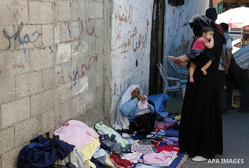 A Palestinian woman sells clothes at a street market in Rafah in the southern Gaza Strip on Sept. 17, 2014. An open-ended ceasefire between Israel and Hamas-led Gaza militants, mediated by Egypt, took effect on August 26...