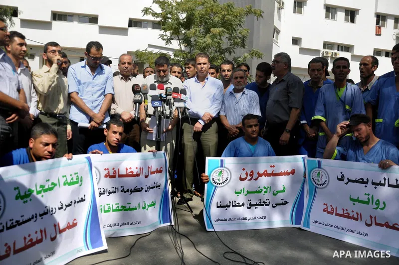 Palestinian clean workers hold banners during a protest to demand for pay their salaries, in Gaza City September 17, 2014. An open-ended ceasefire between Israel and Hamas-led Gaza militants, mediated by Egypt, took effe...