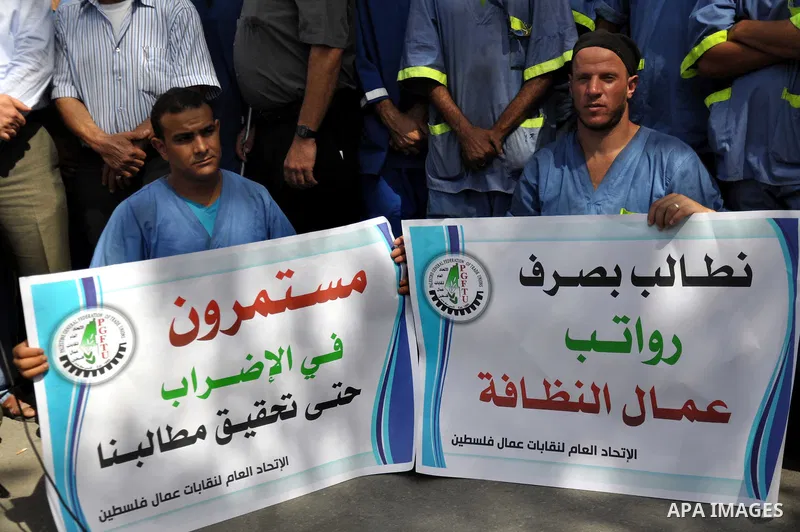 Palestinian clean workers hold banners during a protest to demand for pay their salaries, in Gaza City September 17, 2014. An open-ended ceasefire between Israel and Hamas-led Gaza militants, mediated by Egypt, took effe...