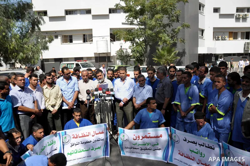 Palestinian clean workers hold banners during a protest to demand for pay their salaries, in Gaza City September 17, 2014. An open-ended ceasefire between Israel and Hamas-led Gaza militants, mediated by Egypt, took effe...