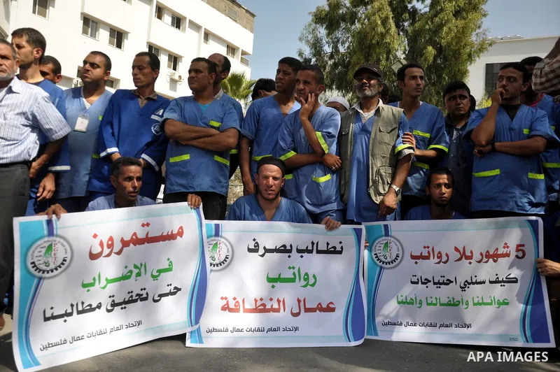 Palestinian clean workers hold banners during a protest to demand for pay their salaries, in Gaza City September 17, 2014. An open-ended ceasefire between Israel and Hamas-led Gaza militants, mediated by Egypt, took effe...