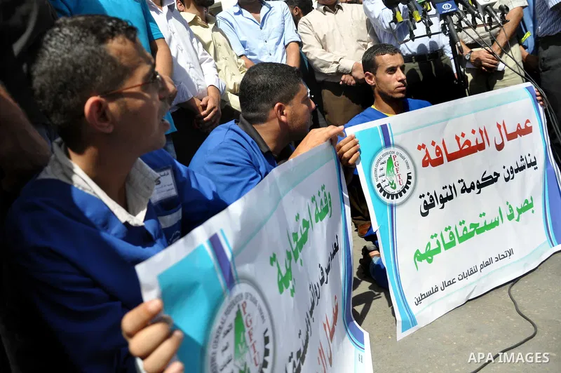 Palestinian clean workers hold banners during a protest to demand for pay their salaries, in Gaza City September 17, 2014. An open-ended ceasefire between Israel and Hamas-led Gaza militants, mediated by Egypt, took effe...