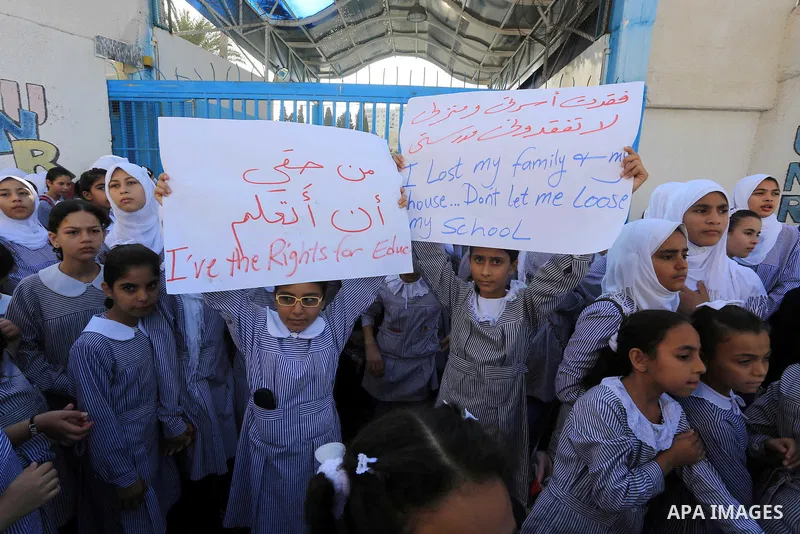 Palestinian Students hold banners during a protest to get out displaced from their schools in front of the headquarters of UNRWA in Gaza City September 18, 2014. An open-ended ceasefire between Israel and Hamas-led Gaza...