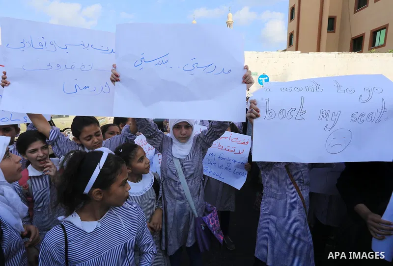 Palestinian Students hold banners during a protest to get out displaced from their schools in front of the headquarters of UNRWA in Gaza City September 18, 2014. An open-ended ceasefire between Israel and Hamas-led Gaza...