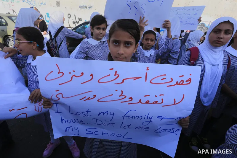 Palestinian Students hold banners during a protest to get out displaced from their schools in front of the headquarters of UNRWA in Gaza City September 18, 2014. An open-ended ceasefire between Israel and Hamas-led Gaza...