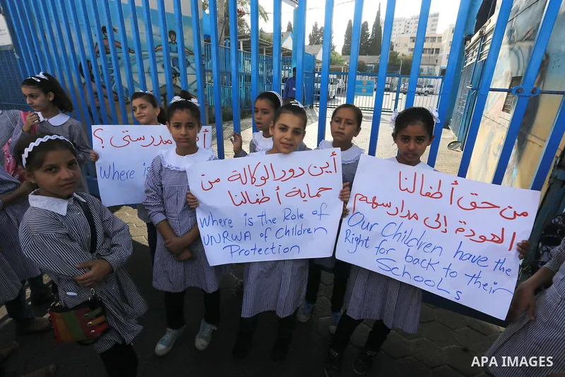 Palestinian Students hold banners during a protest to get out displaced from their schools in front of the headquarters of UNRWA in Gaza City September 18, 2014. An open-ended ceasefire between Israel and Hamas-led Gaza...