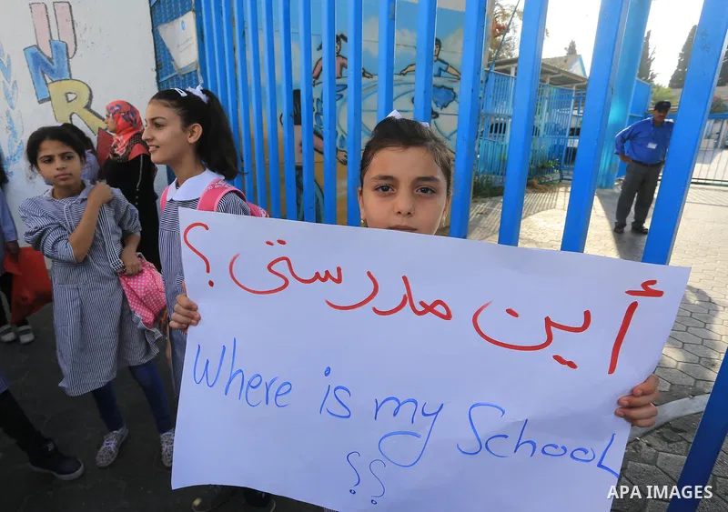 Palestinian Students hold banners during a protest to get out displaced from their schools in front of the headquarters of UNRWA in Gaza City September 18, 2014. An open-ended ceasefire between Israel and Hamas-led Gaza...