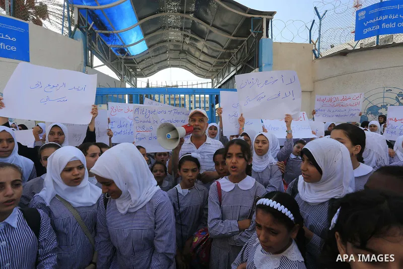 Palestinian Students hold banners during a protest to get out displaced from their schools in front of the headquarters of UNRWA in Gaza City September 18, 2014. An open-ended ceasefire between Israel and Hamas-led Gaza...