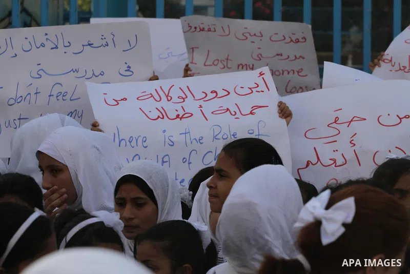 Palestinian Students hold banners during a protest to get out displaced from their schools in front of the headquarters of UNRWA in Gaza City September 18, 2014. An open-ended ceasefire between Israel and Hamas-led Gaza...