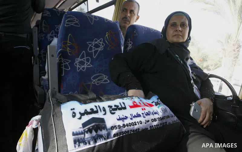 Palestinians Muslim pilgrims wave as they sit in a bus before leaving the Rafah border crossing between Egypt and the southern Gaza Strip, on Sept. 18, 2014, before leaving for the annual hajj pilgrimage to the holy city...