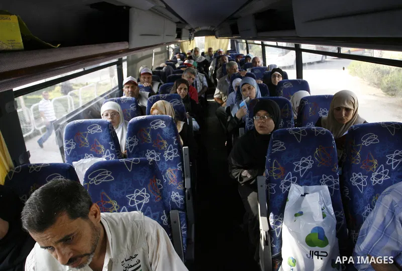 Palestinians Muslim pilgrims wave as they sit in a bus before leaving the Rafah border crossing between Egypt and the southern Gaza Strip, on Sept. 18, 2014, before leaving for the annual hajj pilgrimage to the holy city...