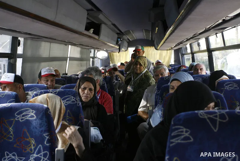 Palestinians Muslim pilgrims wave as they sit in a bus before leaving the Rafah border crossing between Egypt and the southern Gaza Strip, on Sept. 18, 2014, before leaving for the annual hajj pilgrimage to the holy city...