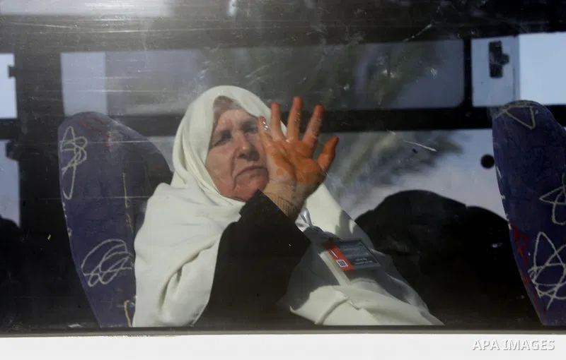 Palestinians Muslim pilgrims wave as they sit in a bus before leaving the Rafah border crossing between Egypt and the southern Gaza Strip, on Sept. 18, 2014, before leaving for the annual hajj pilgrimage to the holy city...